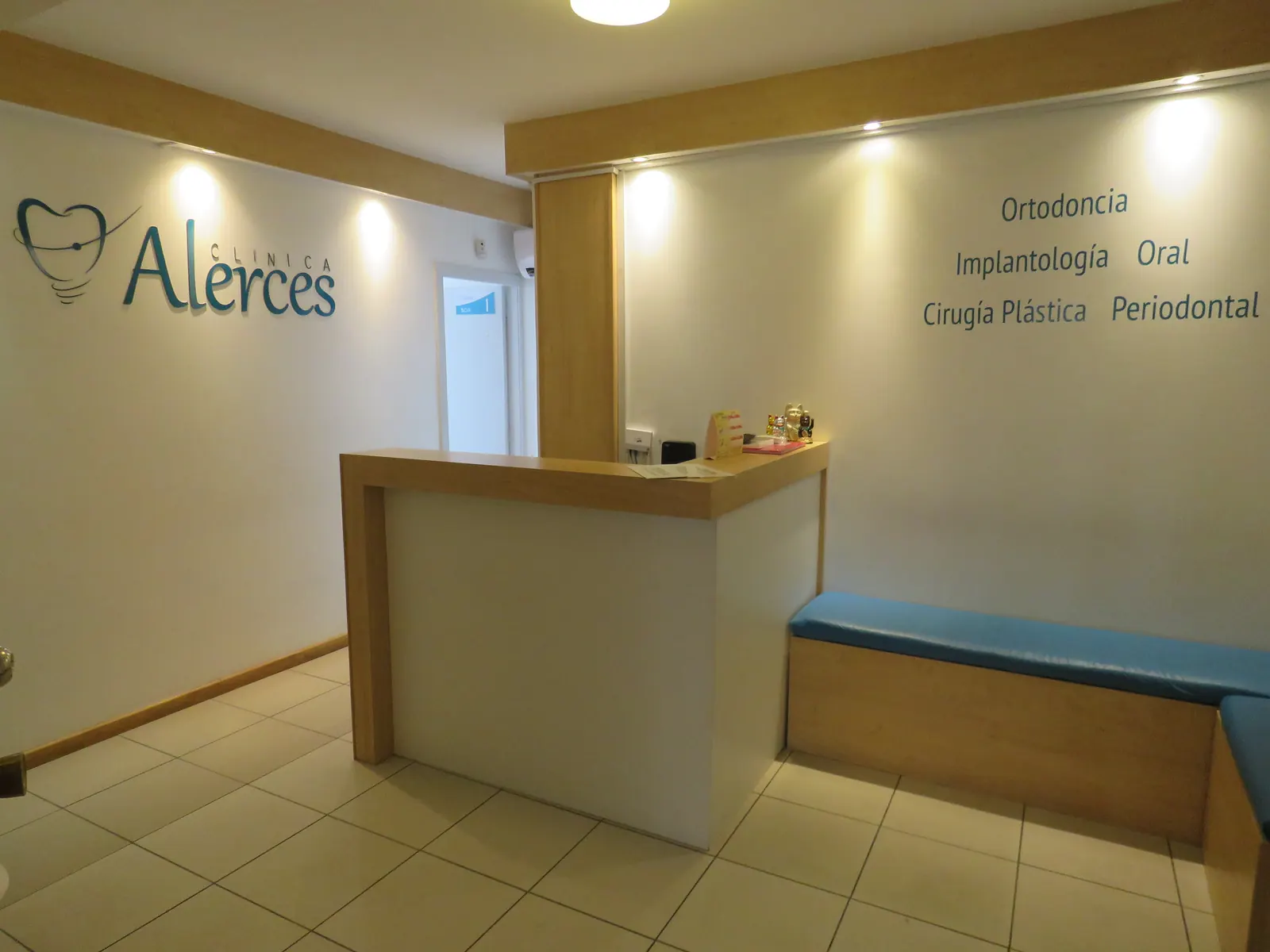 Recepción de Clínica Alerces con sus especialidades en la pared (foto real)